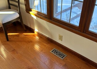 Late afternoon shaft of light streaming onto oak hardwood floors in a suburban home
