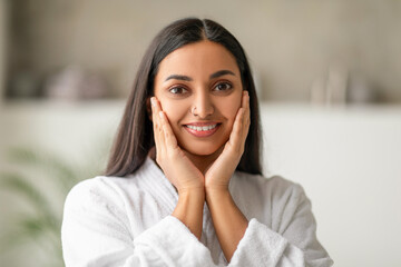 Beautiful long-haired young indian woman touching her face