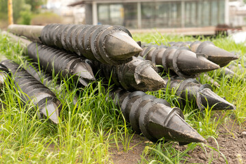 Screw piles for terrace foundations. Geo screws are steel round elements of an engineering structure. Industrial maintenance of metal tools for architectural construction work.