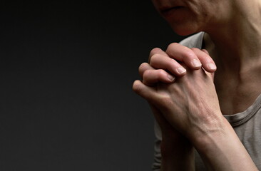 woman praying with hand over her face on black background with people stock image stock photo