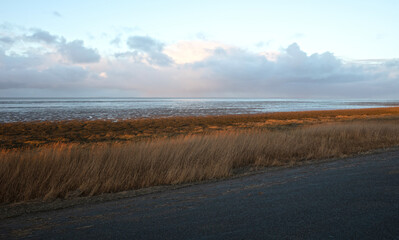 Dutch wide landscape with dike and winter sky, Waddensea