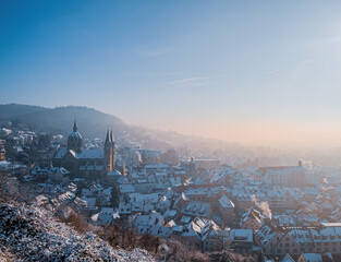 panoramic view over a German town in the winter with snow-covered roof and warm morning mist