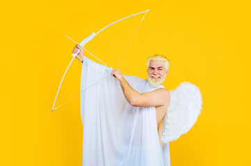 Valentines Day celebration. Smiling bearded man in angel costume aiming with bow. God of love....