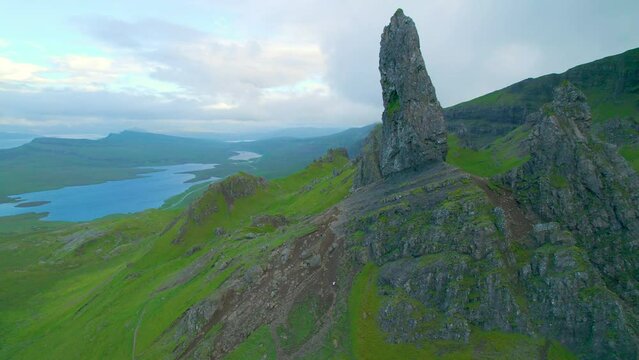 AERIAL: Picturesque rock formations above lakes and green valley on Isle of Skye. Breathtaking view of Old Man Of Storr on the edge of grassy Trotternish Ridge, famous natural attraction in Scotland.