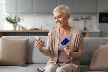 senior woman shopping online making digital payment via smartphone indoor