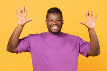 Joyful African man raising both hands showing number ten, studio