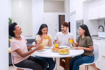 Diverse ethnic friends gathered for a lively breakfast in a modern white kitchen