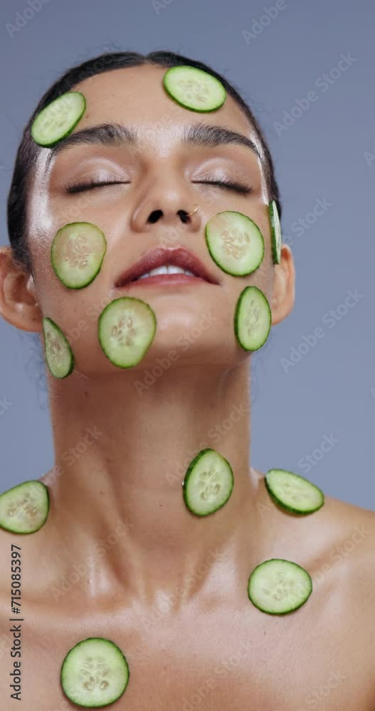 Poster Face, cucumber on skin and woman with natural beauty, vegan or eco friendly product with wellness for skin in studio. Zen, detox and green fruit, self care with cosmetics and calm on grey background