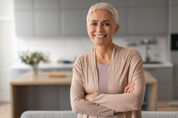 Portrait of confident senior woman with short hair crossing hands - Powered by Adobe