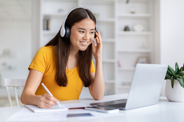 Obraz premium Distance Learning. Asian Woman In Headset Study Online With Laptop At Home