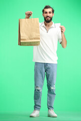 A man, full-length, on a green background, with bags