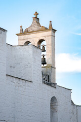 View of the bell tower of the little white church in Italy