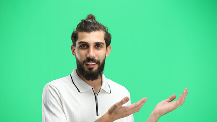 A man, close-up, on a green background, points to the side