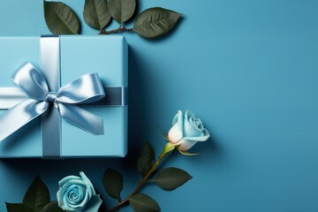  a blue gift box with a blue ribbon and a white rose on a blue background with a blue ribbon and two white roses.