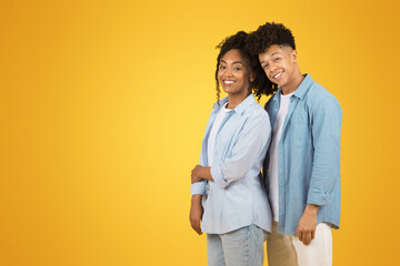 Two happy young woman and a man with curly hair, wearing casual blue shirts