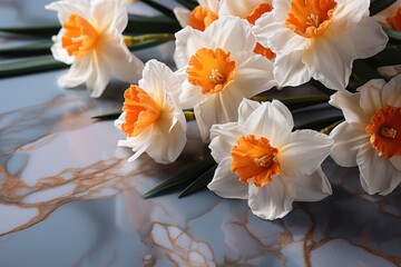  a group of white and orange flowers sitting on top of a marble counter top next to a green leafy plant.