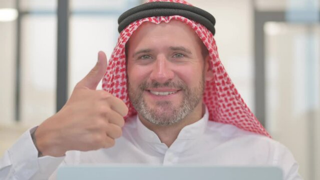 Close up of Arab Man with Thumbs Up while Working on Laptop