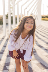 beautiful little girl of Arab appearance with long hair walks in a city park in summer