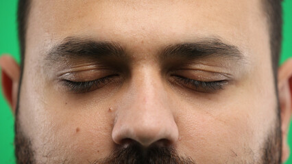 Obraz premium Man's eyes, close-up, on a green background