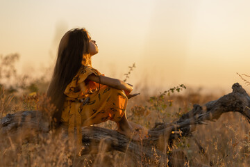 Obraz premium Beautiful little girl of Indian appearance at sunset in summer, long hair,