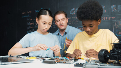 Smart mentor teach main board construction while diverse teenager learning system. Teacher explain...