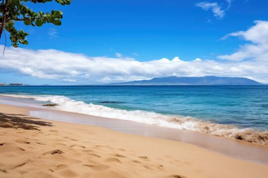  a sandy beach next to the ocean under a blue sky with clouds and a mountain in the distance on a sunny day.