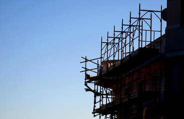 Silhouette of scaffolding on a construction site with blue sky in the background - 715109357