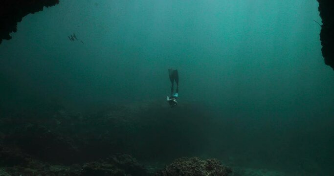 Woman doing a deep free dive then going back towards the surface.