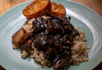 Cuttlefish in its ink with brown rice and croutons. Galicia, Spain.