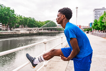 Active Preparation: Young African American Stretching by the Urban River