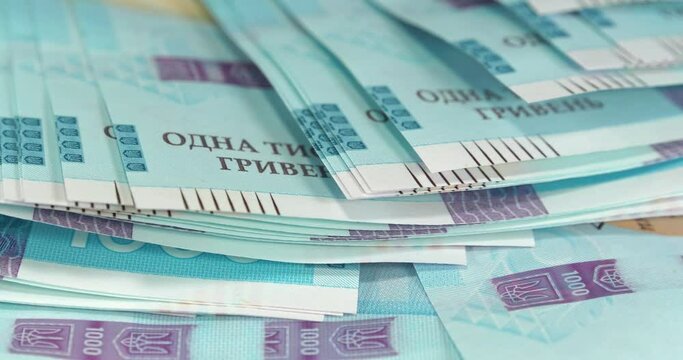 Money of Ukraine. New banknotes 1000 Hryvnia in uncirculated condition, UNC. Real Ukrainian paper money of blue yellow color, UAH. Ukrainian banknotes of max denomination. Cinema 4K 60fps video