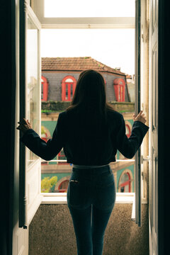Mujer asomada a la ventana en edificio antiguo de Oporto
