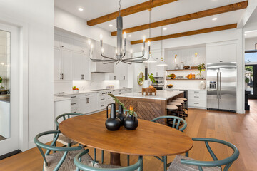 Kitchen and dining room in new luxury home with pendant lights, hardwood floors, stainless steel...