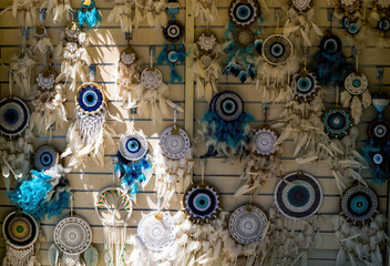 handmade knitting against the evil eye hanging on a wall in a souvenir shop in Greece, background...