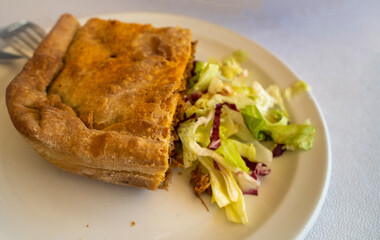 A greek cuisine puff pastry on a plate with pie stuffed with vegetables and chicken