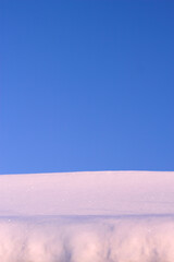 snow drift and blue sky in sunny winter day