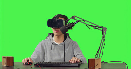 POV of streamer using virtual reality glasses and broadcasting live action gameplay while sitting at desk, playing online competition. Content creator records a arcade stream using vr headset.