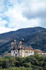 Fototapeta na wymiar Church Sao Francisco de Paula with the mountains on background. Ouro Preto, Minas Gerais, Brazil.