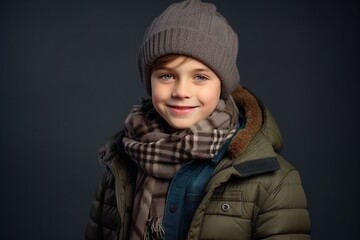 Portrait of a cute little boy in warm clothes over dark background.