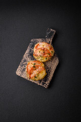 Delicious baked fish fillet with cheese, tomatoes, salt, spices and herbs