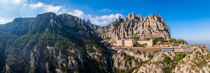 Aerial view of the Benedict church Abbey of Monserrat from Barcelona, Spain. Montserrat Monastery, Santa Maria de Montserrat is a Benedictine abbey located on the mountain of Montserrat - obrazy, fototapety, plakaty