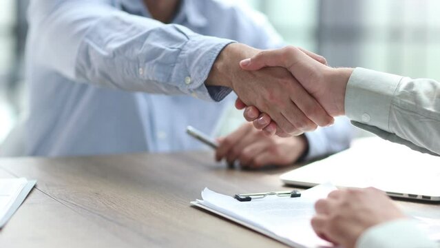 Businessman hand signing contract paper at the desk