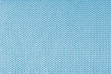 Close up background of knitted wool fabric made of viscose yarn, blue color wool knitwear texture. Sweater, pullover knitted jersey background. Fabric abstract backdrop, wallpaper