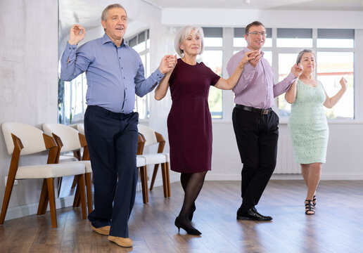 Elderly people with middle-aged man holding hands dancing hava nagila. Dance lessons for amateurs and beginners