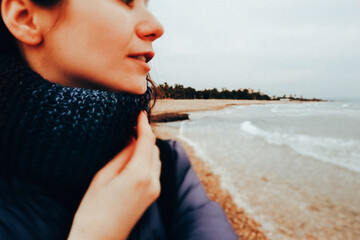 Happy calm young woman, girl 25 years old portrait on the background of the sea, ocean in the cold...
