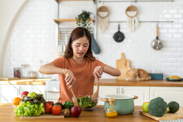 Obraz na płótnie Canvas Portrait of beauty body slim healthy asian woman eating vegan food healthy with fresh vegetable salad in kitchen at home.diet, vegetarian, fruit, wellness, health, green food.Fitness and healthy food.