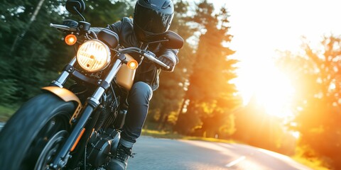 Biker in helmet and leather jacket riding on motorcycle on country road.