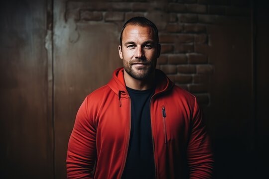 Portrait of a handsome man in a red hoodie. Studio shot.