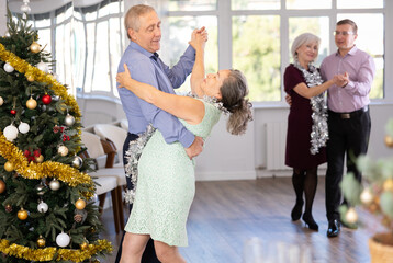 Couple of elderly man and elderly woman dancing waltz in studio