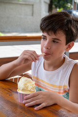 10 year old Brazilian child eating ice cream on a sunny afternoon_2.